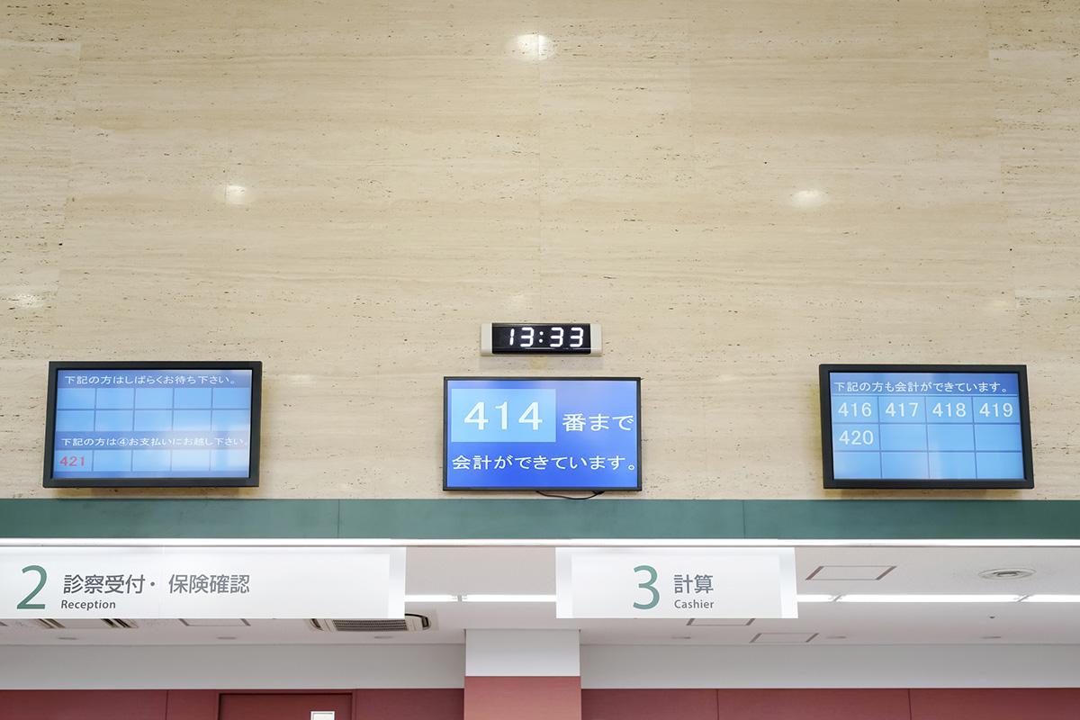 病院の受付で順番待ちの番号が表示されるデジタルサイネージ