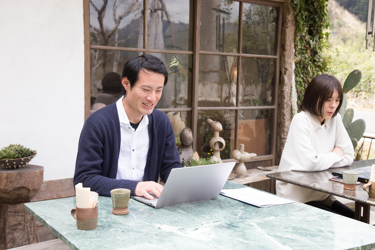 カフェでPCを前にリモートワークをする人