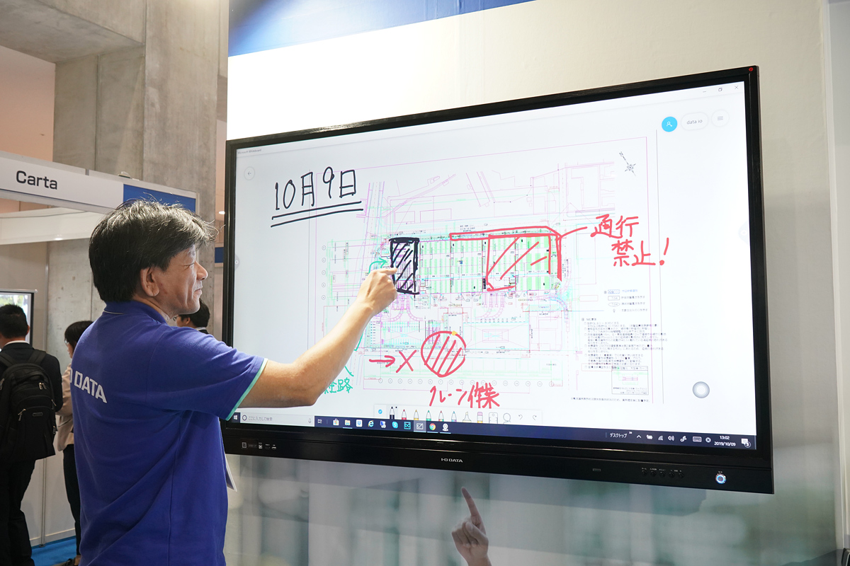 電子黒板に表示された図面に指で書き込む